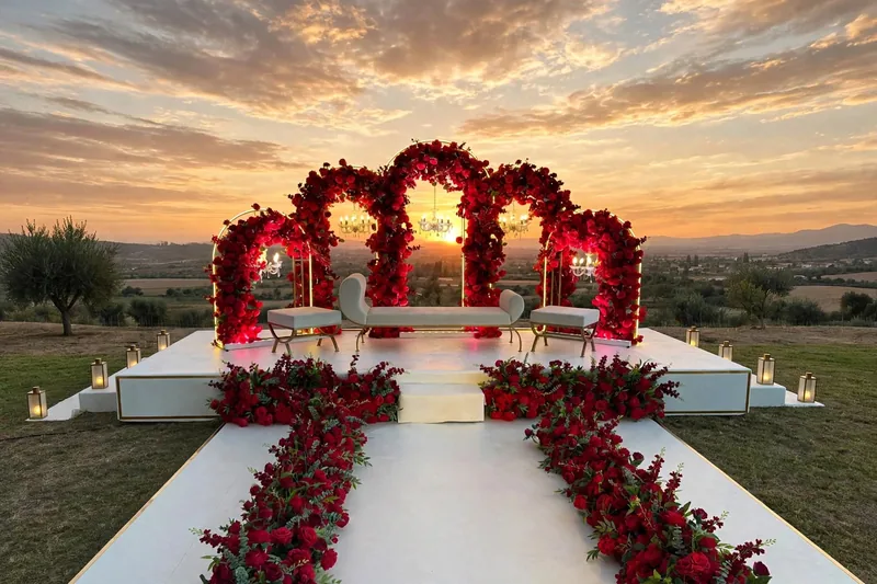 Outdoor Rose Arch Barat Stage: Red rose arches on an open white stage with a red rose walkway and lanterns, GuleGul Flowers Lahore