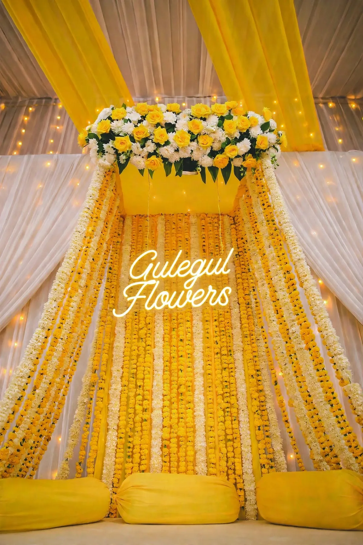 Yellow Genda Mehndi Canopy: Yellow canopy with yellow and white genda flower strings, a flower crown and yellow floor cushions, GuleGul Flowers Lahore